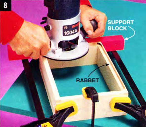 Using a support block, rout the bottom rabbets in the drawers