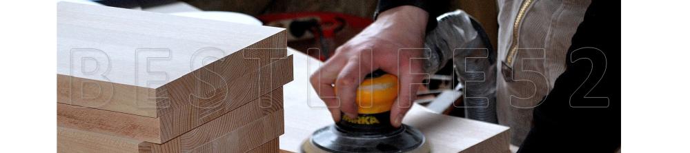 detail of man using a random orbit sander and sanding pine boards