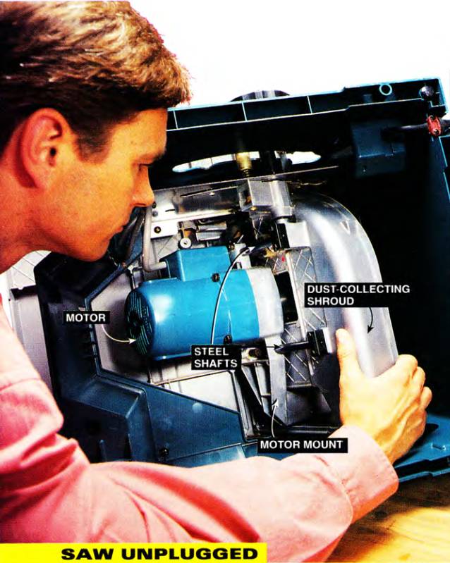 Looking under the DeWalt DWE7491RS portable table saw to see the cast aluminum motor mount, the dust-collecting shroud, the steel shafts, and the motor itself.